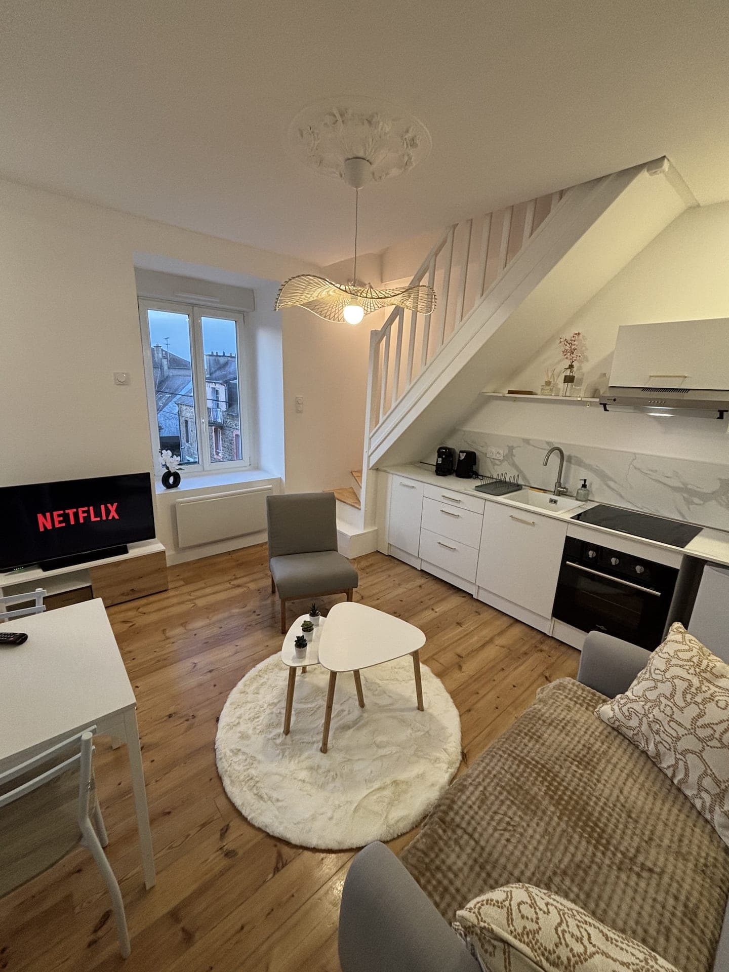 Séjour avec coin salon, télévision et cuisine ouverte
