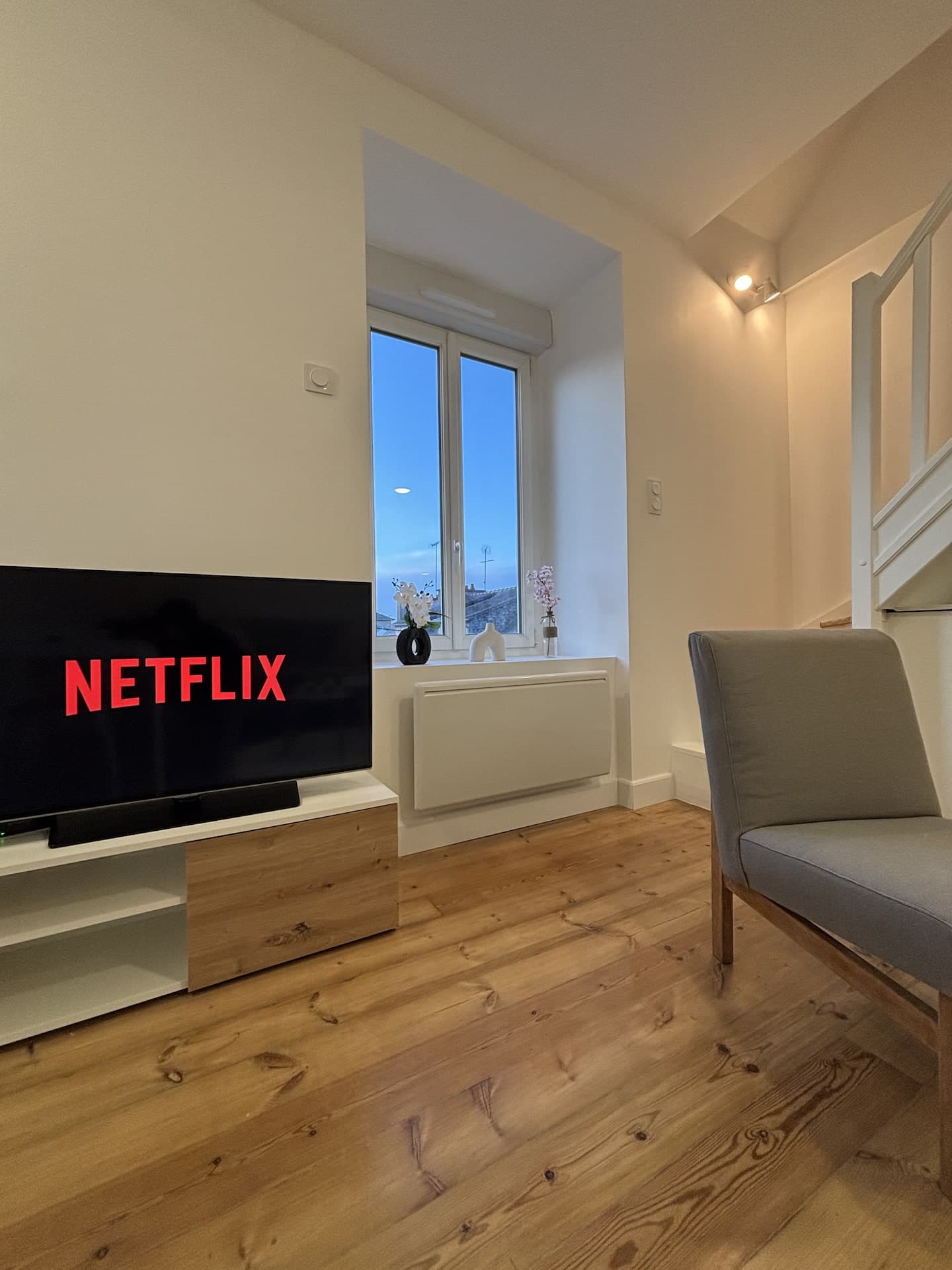 Coin salon avec télévision et fauteuil près de la fenêtre